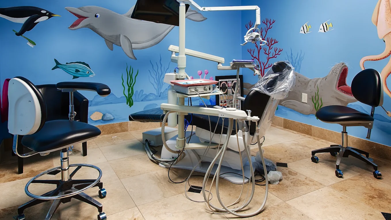 Dental treatment chair and equipment in a blue room with ocean-life murals